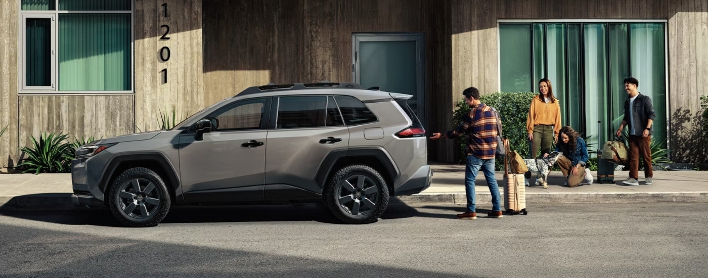 People near a grey 2026 Toyota RAV4