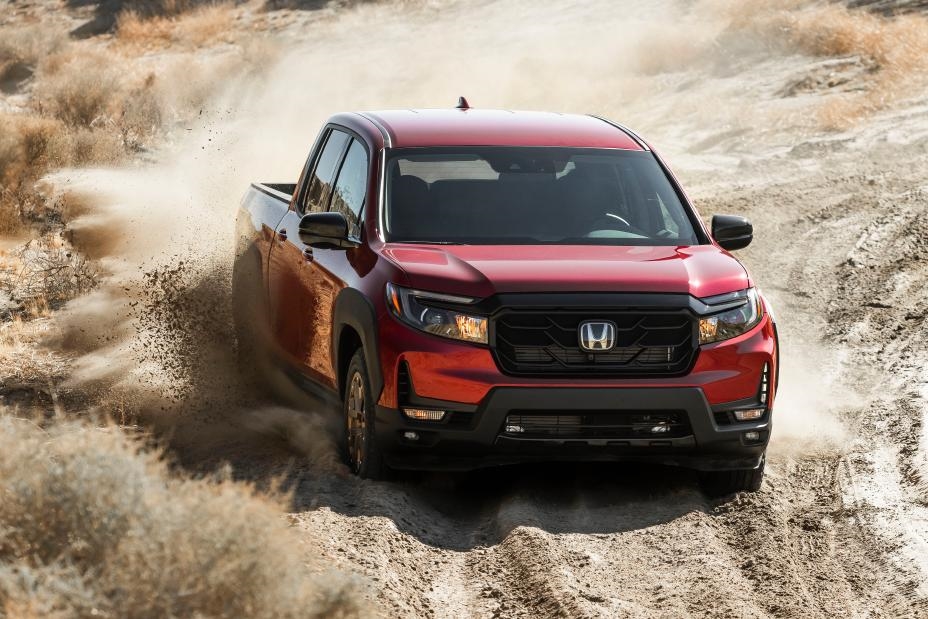 A red Honda Ridgeline driving through the desert
