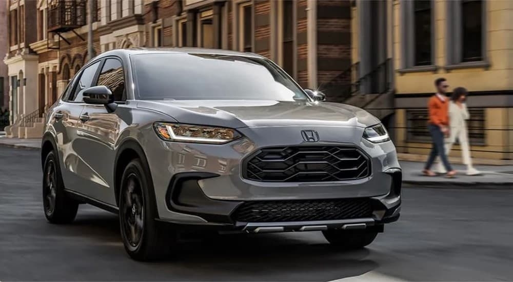 A gray 2023 Honda HR-V Sport driving to view used cars for sale near Marysville.