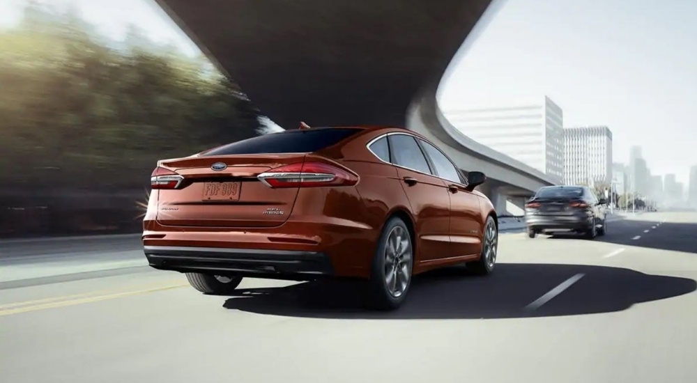 A bronze 2019 Ford Fusion Hybrid SEL driving past a ramp.