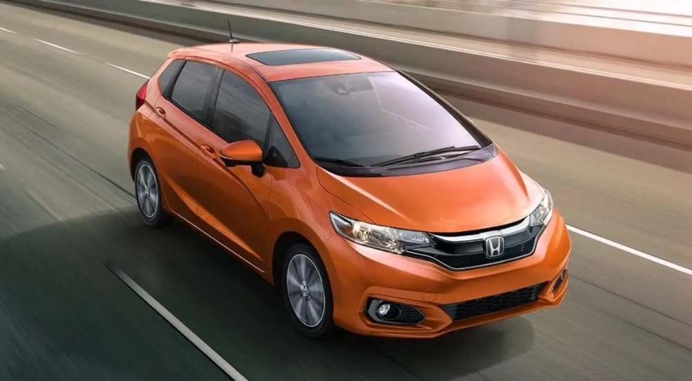 An orange 2020 Honda Fit EX-L driving to view used cars for sale near Marysville.