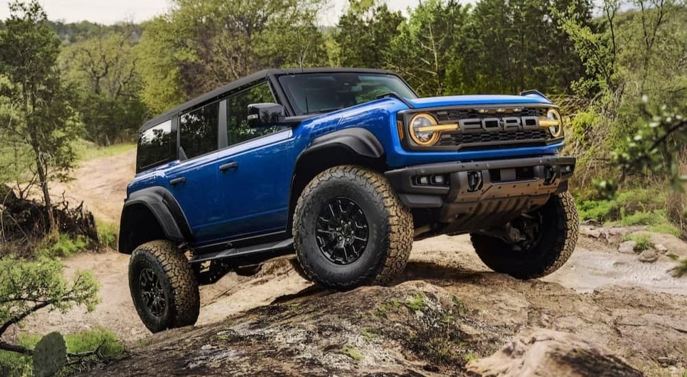 A blue 2025 Ford Bronco Raptor parked off-road.