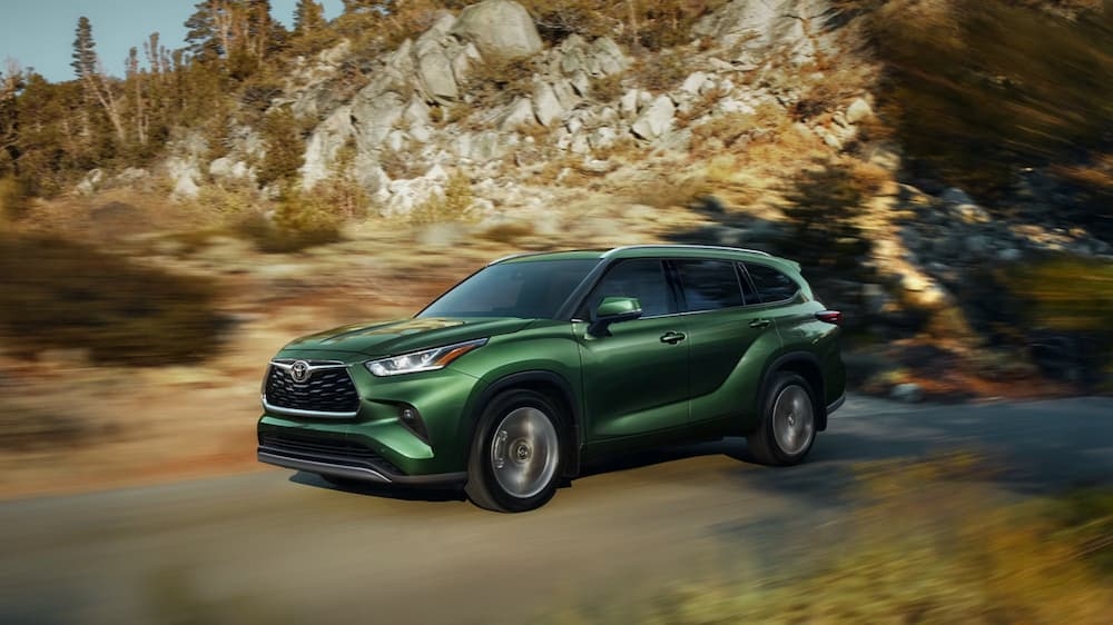 A green 2025 Toyota Highlander driving off-road.