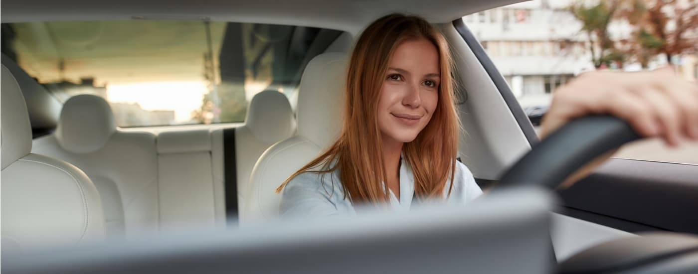 Woman driving to sell her car at a dealership.