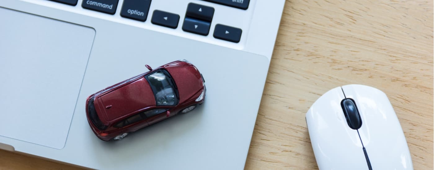 Red toy car on a laptop.