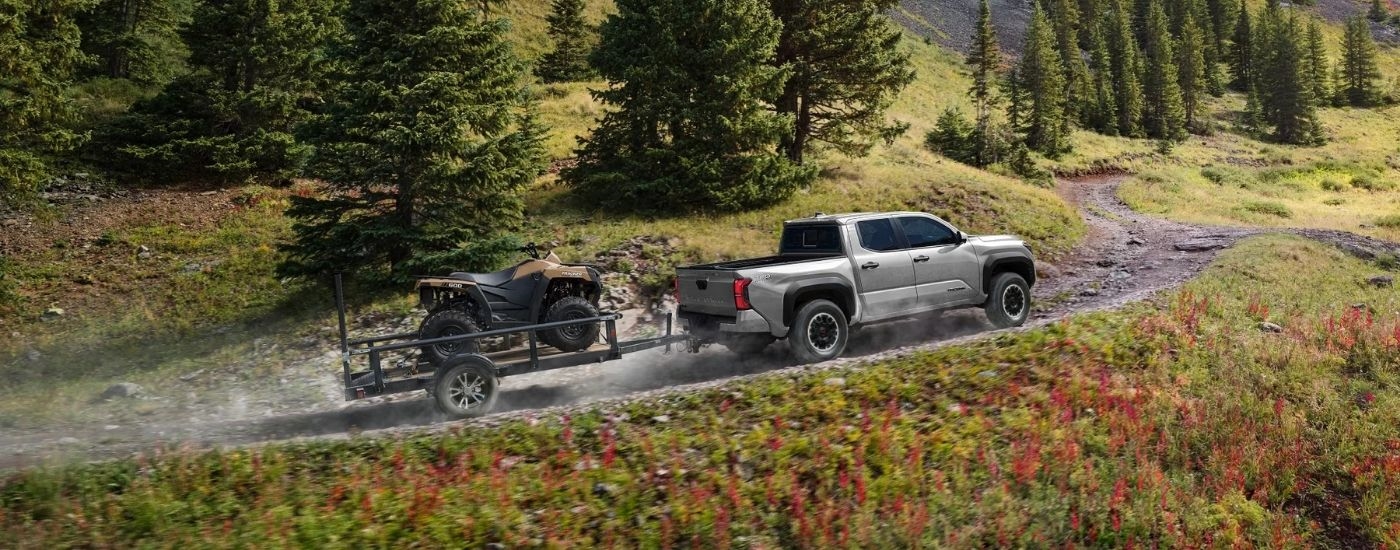 A silver 2025 Toyota Tacoma from the side while off-road.