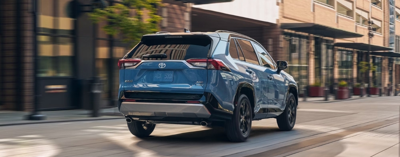 A blue 2025 Toyota RAV4 Hybrid from the rear.