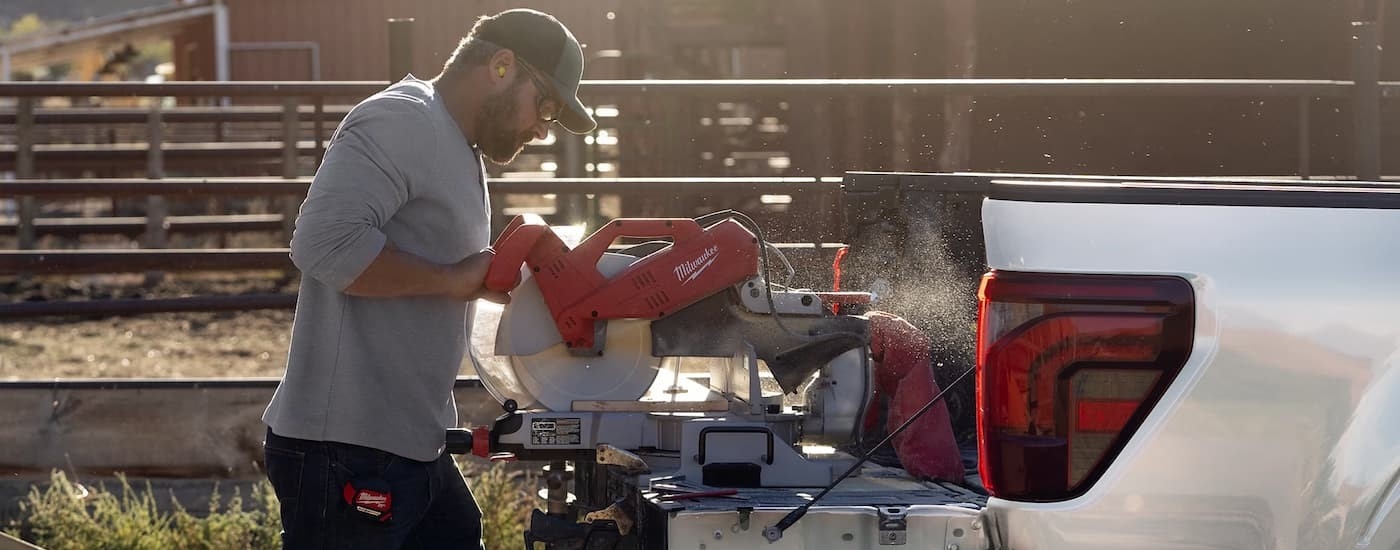 A person using a saw on the bed of a 2025 Ford F-150 for sale in Westminster.
