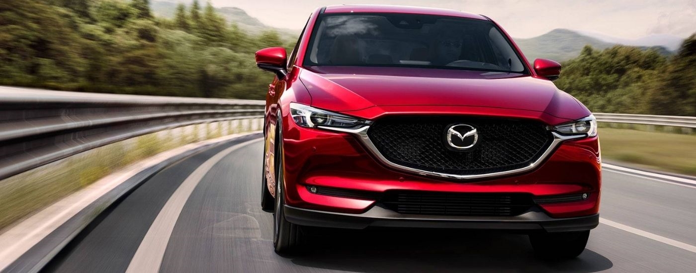 A red 2019 Mazda CX-5 Grand Touring Reserve driving on an open road.