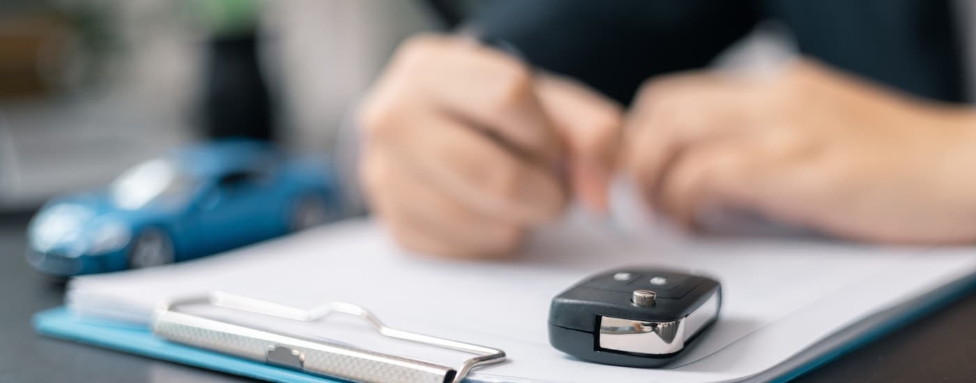 Person doing financing paperwork at a car dealership
