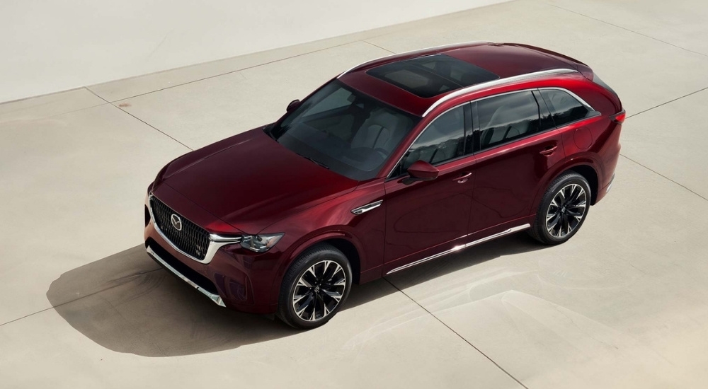A maroon 2025 Mazda CX-90 for sale parked on concrete.