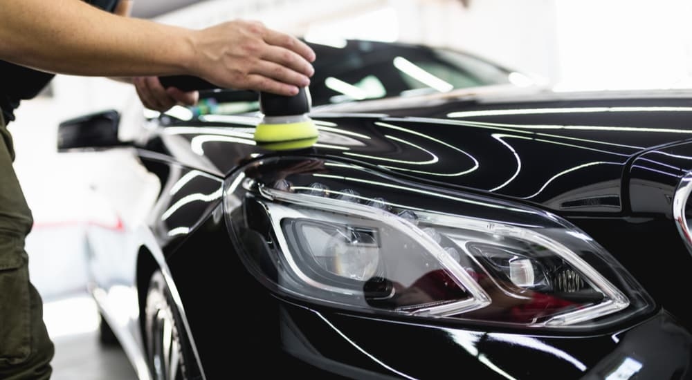 Close up of a person cleaning a black sedan