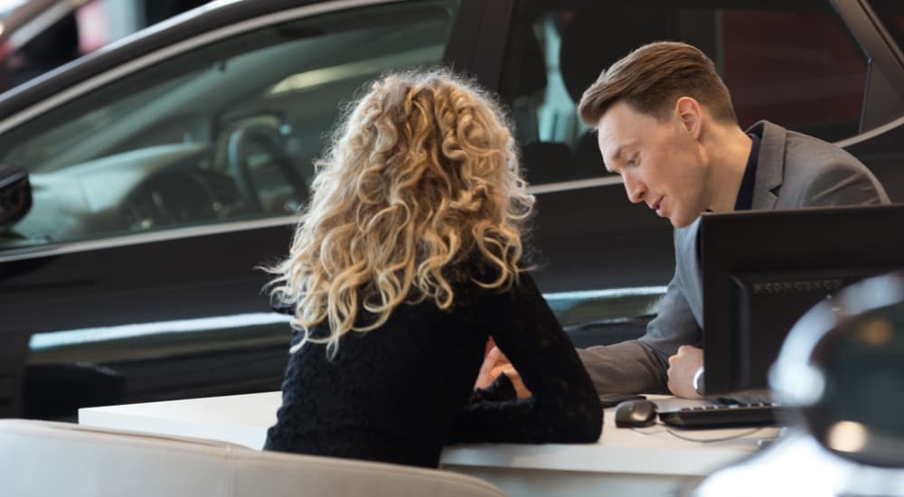 Car salesman and customer speaking about how to sell their car