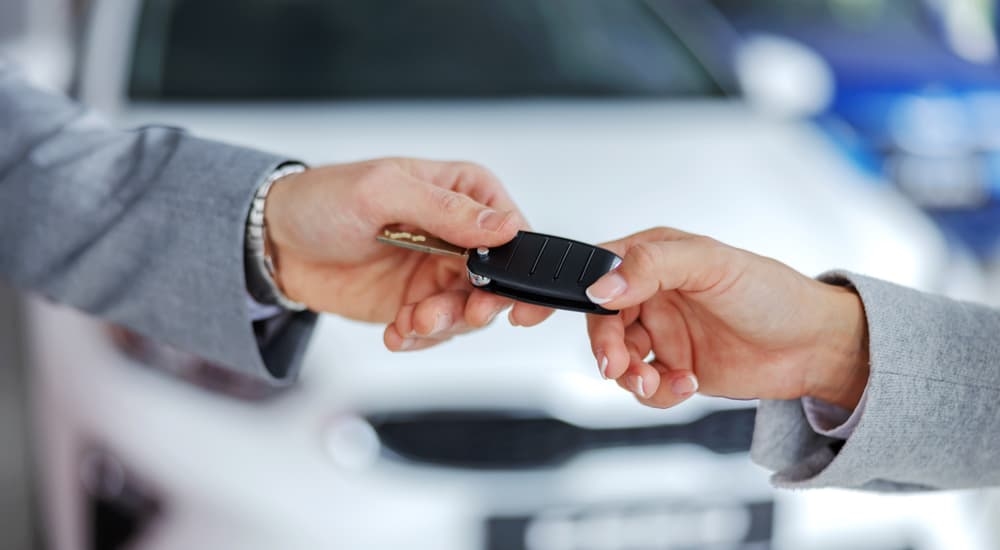 Two hands exchanging a car key