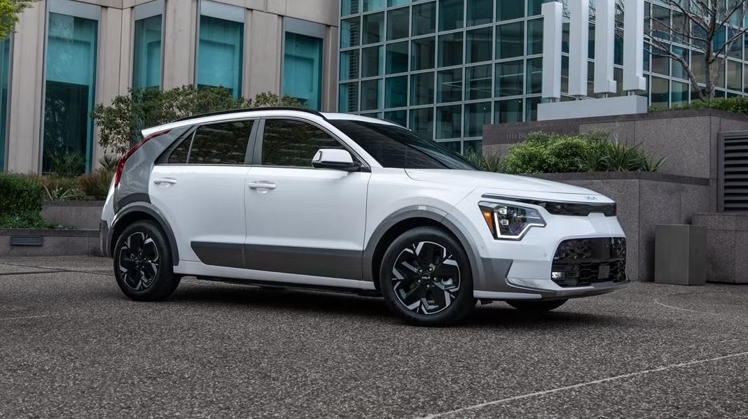 2026 KIA Niro EV in white parked in an urban center. Find yours at Castle KIA in McHenry, IL.