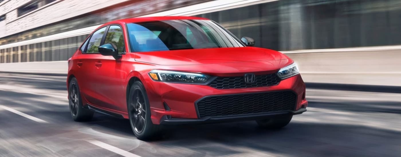 A red 2026 Honda Civic driving to a Honda dealer near Union.