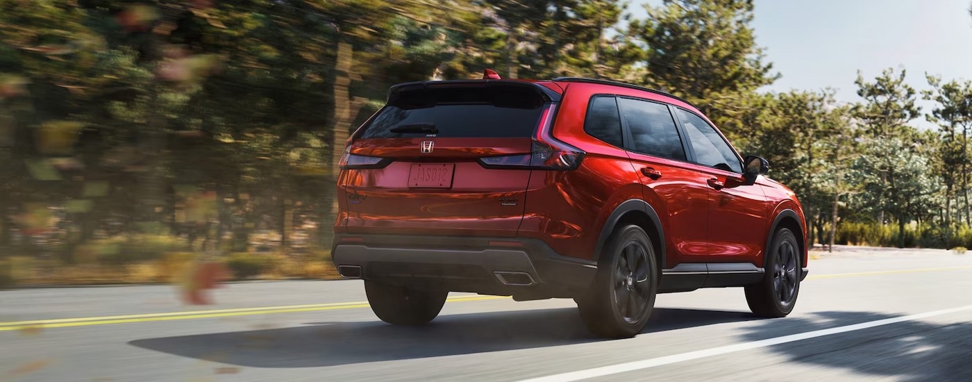 A red 2026 Honda CR-V is driving on a highway.