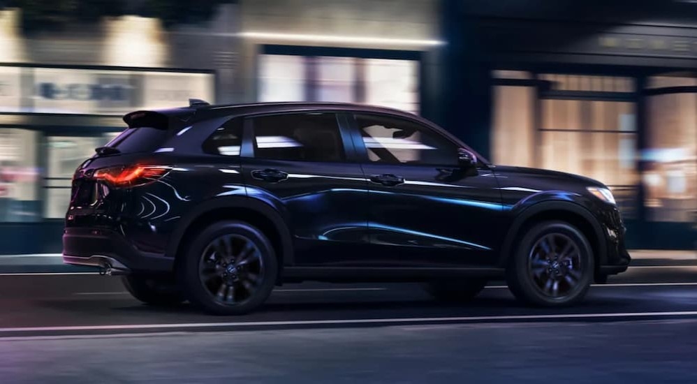 A black 2026 Honda HR-V driving in a city at night.