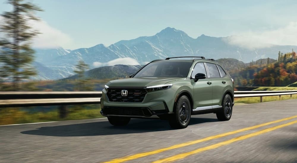 A green 2026 Honda CR-V TrailSport for sale near Mill Creek driving on a highway.