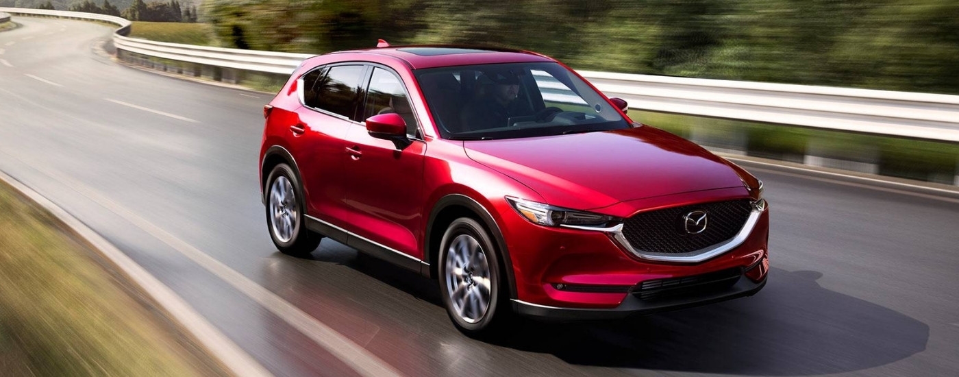 A red 2019 Mazda CX-5 Grand Touring Reserve driving on a highway.