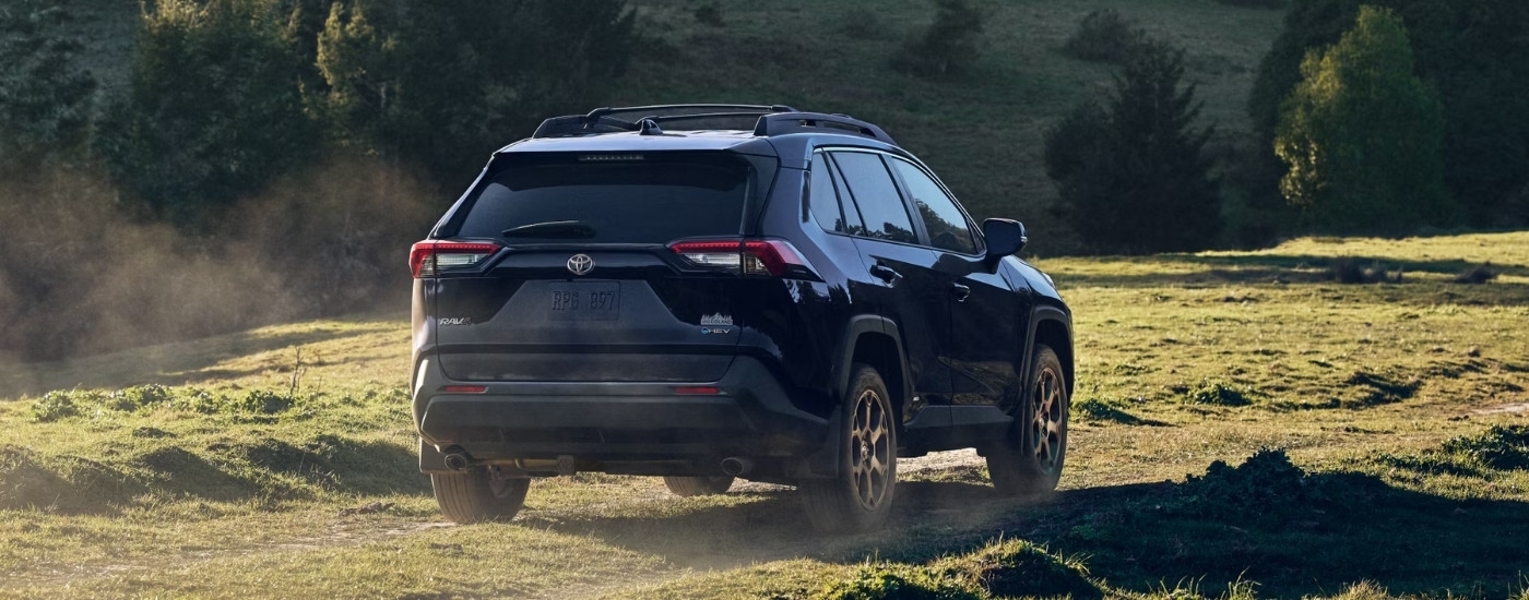 A blue 2025 Toyota RAV4 Hybrid for sale near Brattleboro from the rear at an angle.