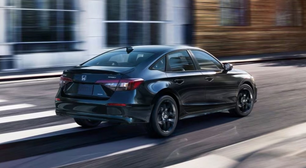 A black 2026 Honda Civic driving on a city street.