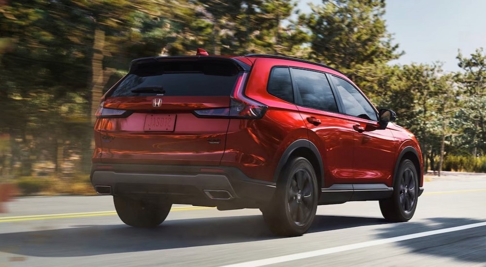 A red 2026 Honda CR-V driving on a highway.