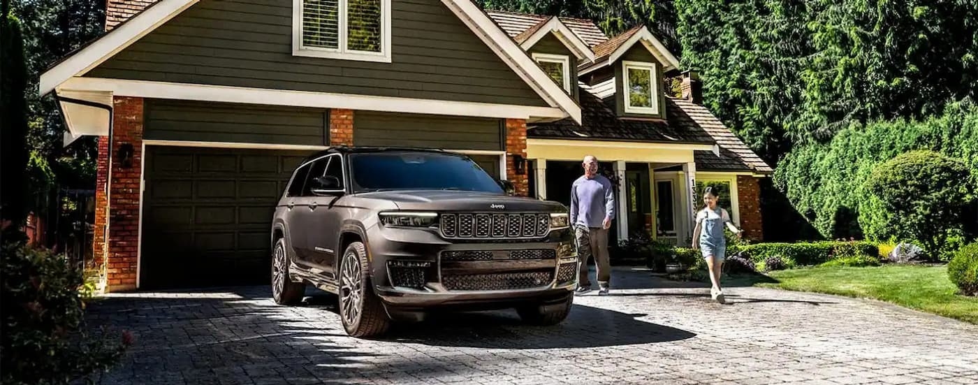 A gray 2025 Jeep Grand Cherokee parked on a driveway.