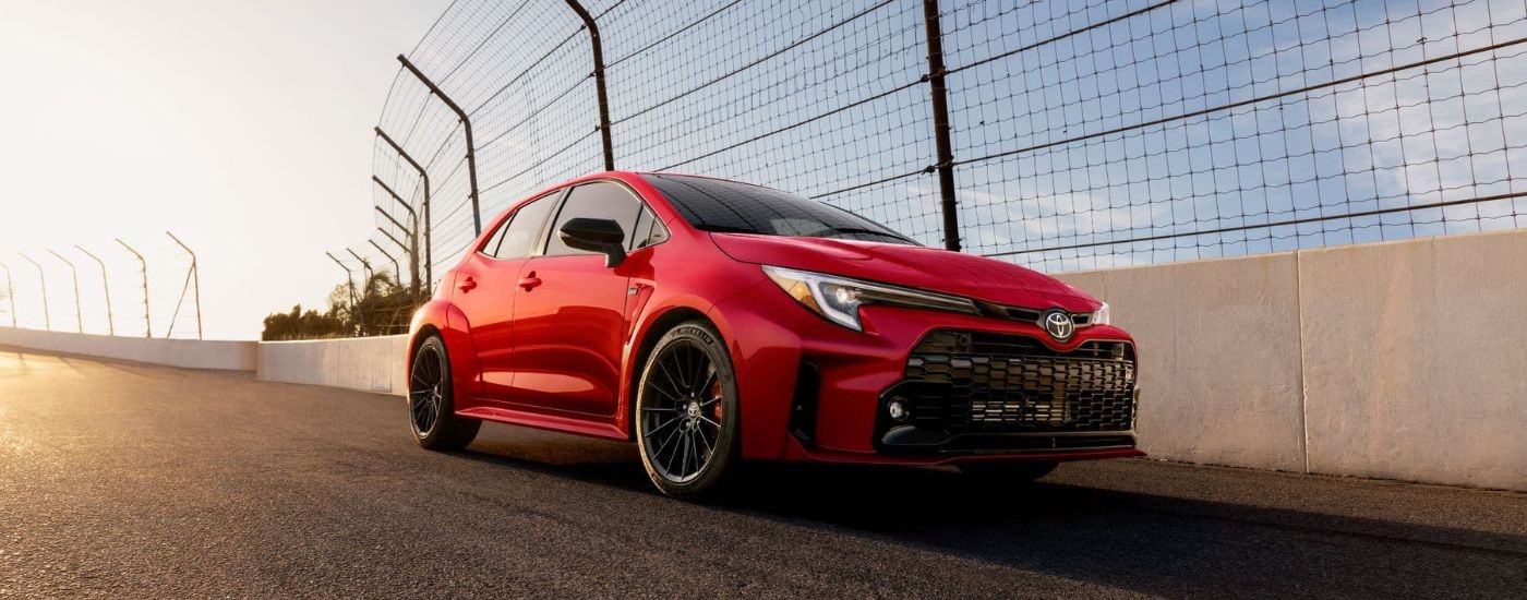Red 2024 Toyota GR Corolla driving on a track.