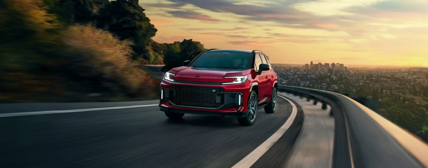 A red 2026 Toyota RAV4 PHEV GR Sport rounding a corner.