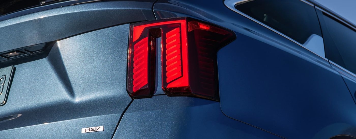 Close up on the taillight of a blue 2024 Kia Sorento Hybrid.