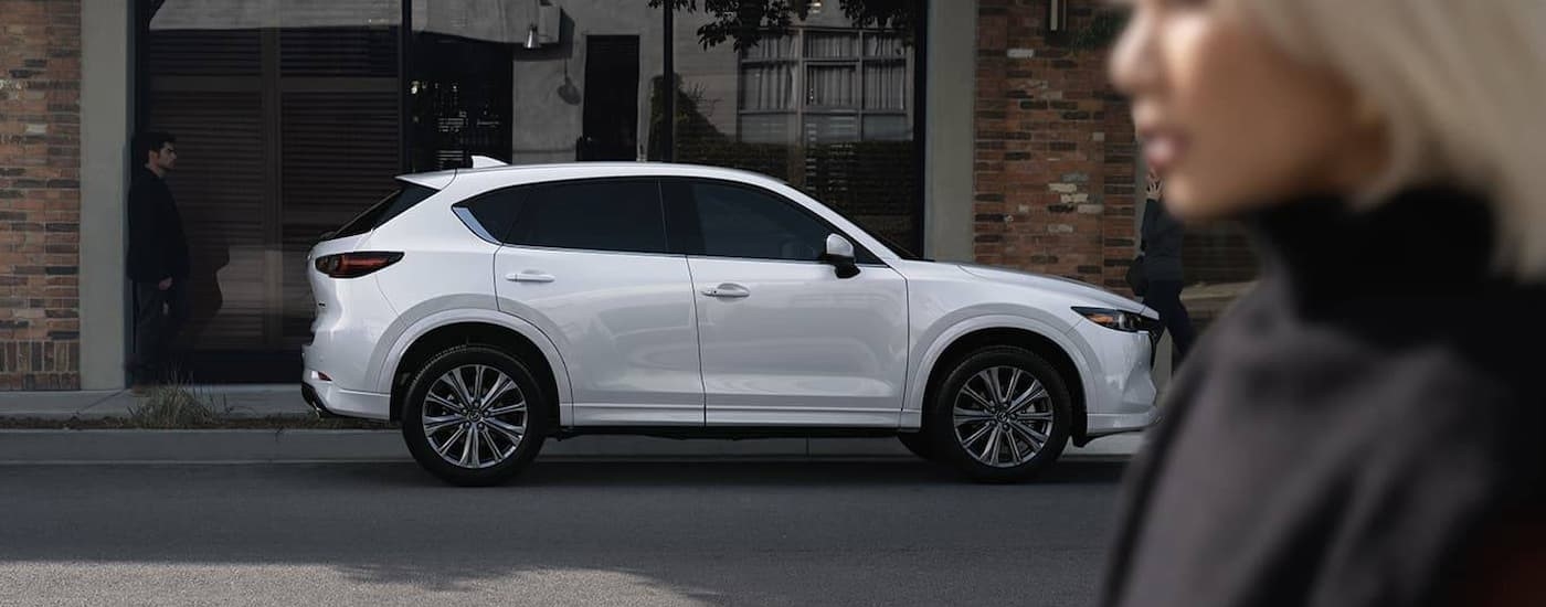 Side of a white 2025 Mazda CX-5 parked by a curb.