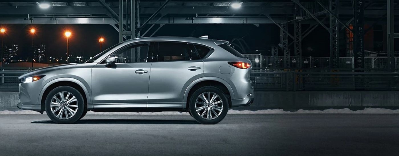 Red 2025 Mazda CX-5 driving down a dirt road.