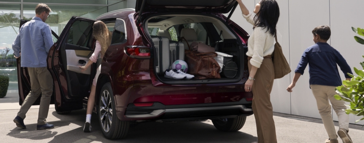A family getting into a 2024 Mazda CX-90 for sale in Miami.