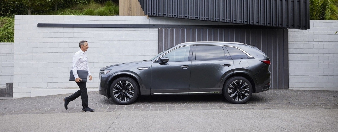 A person approaching a grey 2025 Mazda CX-90