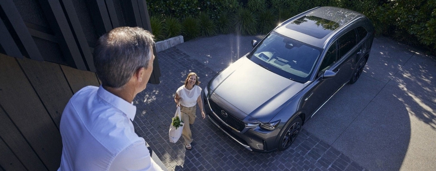 A couple near a grey 2025 Mazda CX-90.