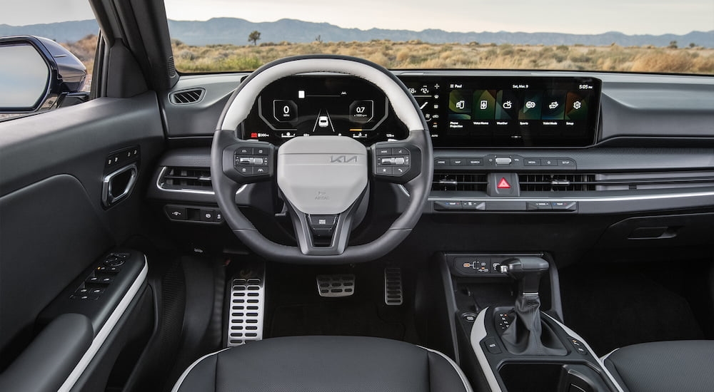 White and grey steering wheel and dashboard in a 2025 Kia K4.