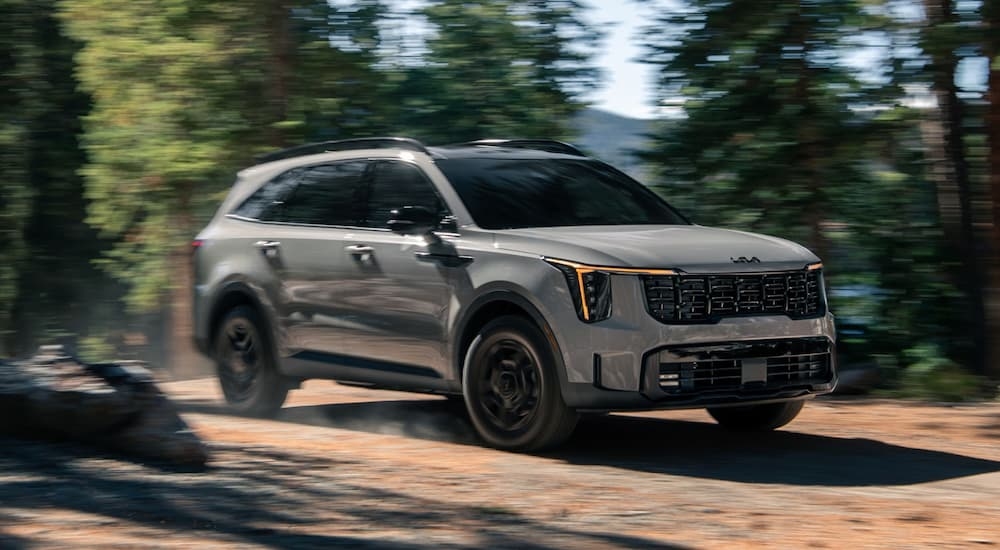 Grey 2026 Kia Sorento X-Pro SX Prestige driving down a dirt road.