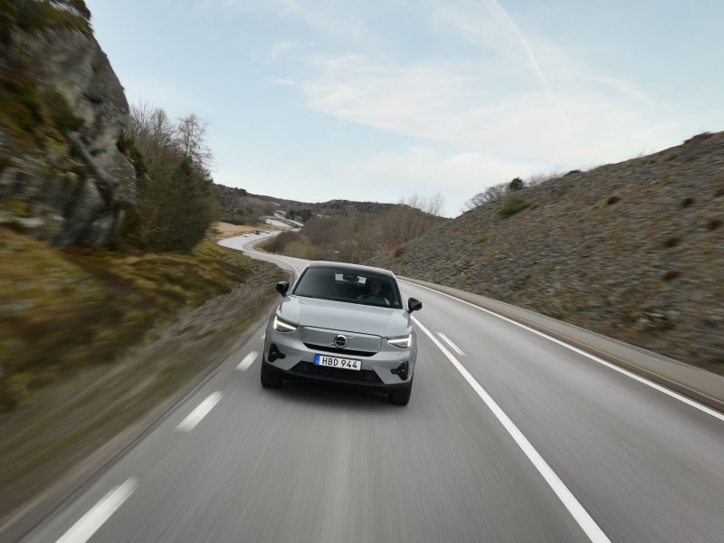 Volvo C40 driving on winding scenic mountain road with motion blur
