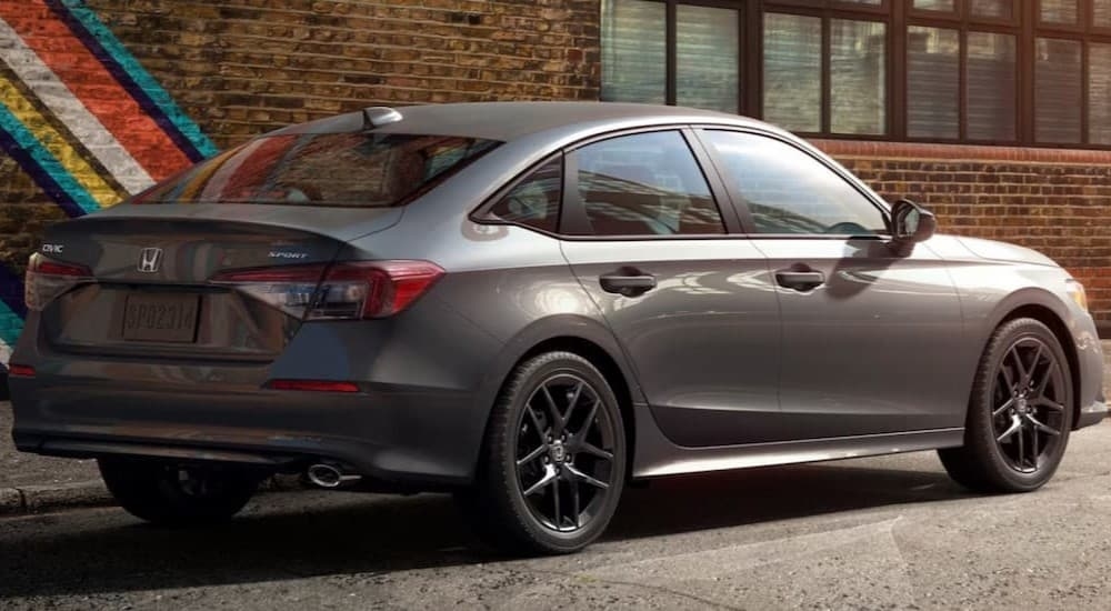 A gray 2026 Honda Civic parked near a brick wall.