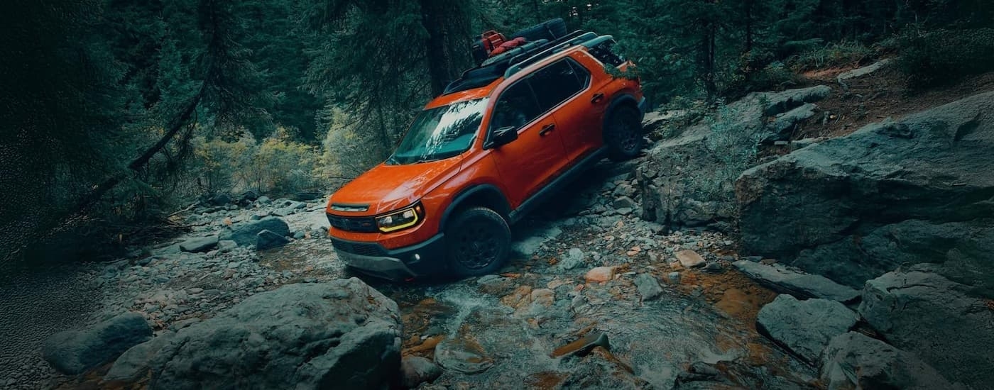 An orange 2026 Honda Passport TrailSport Elite off-roading.