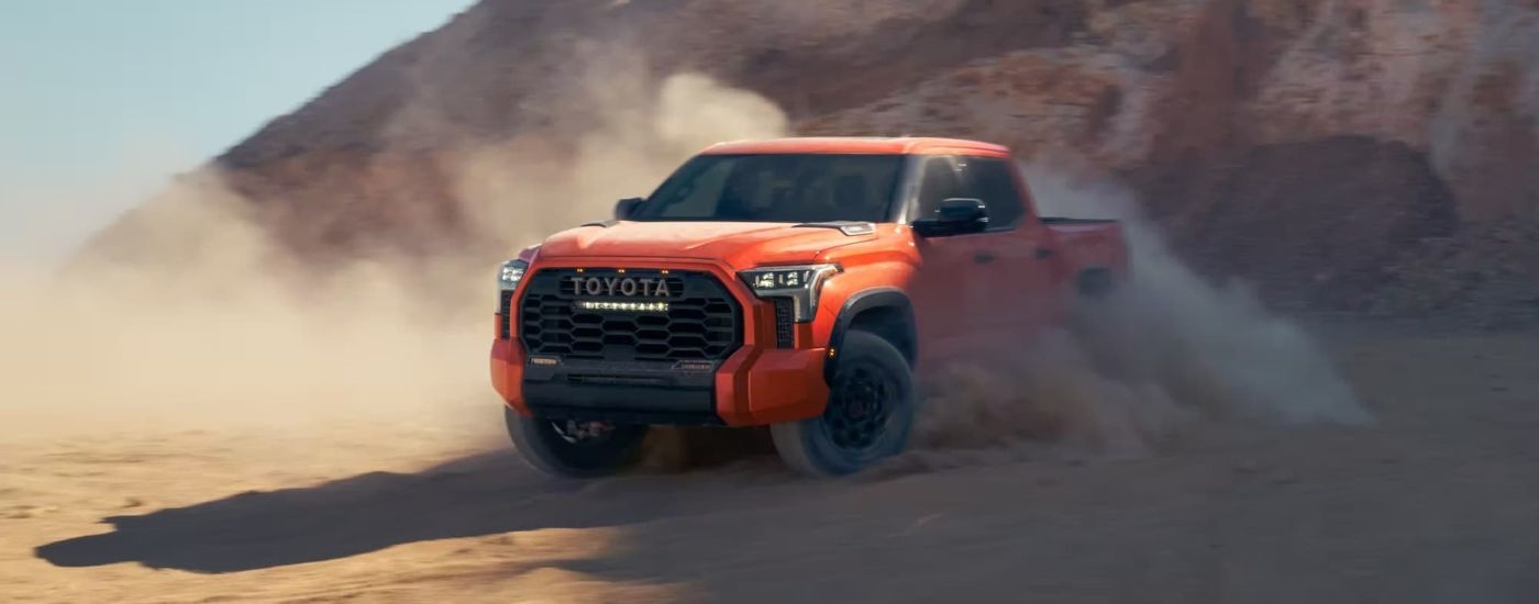 Orange 2025 Toyota Tundra TRD Pro driving through a desert.