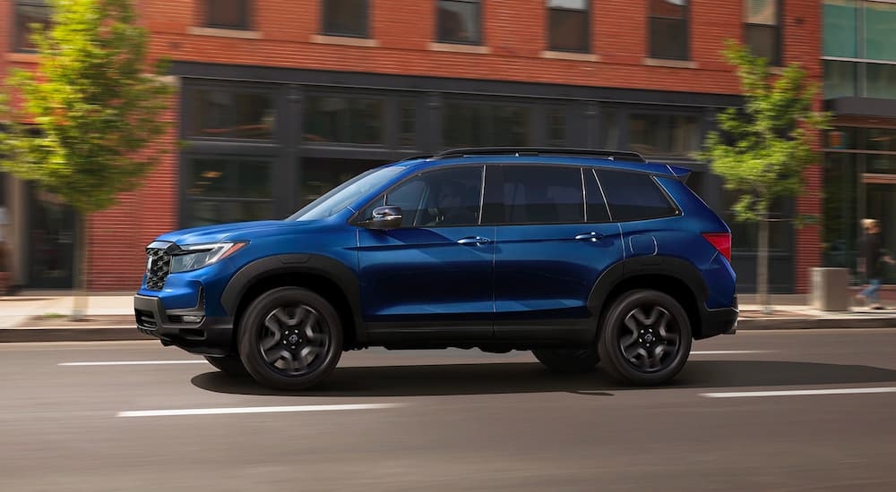 A blue 2023 Honda Passport driving to view a used Honda for sale near Weehawken.