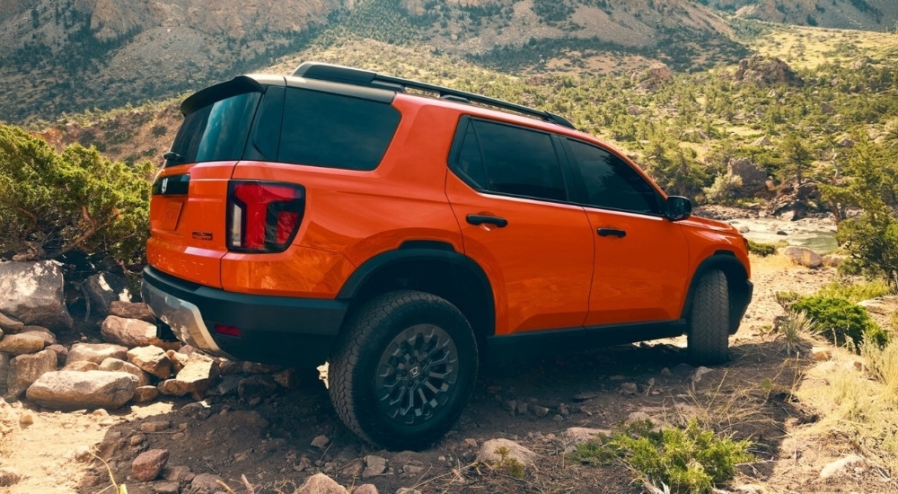 An orange 2026 Honda Passport TrailSport Elite off-roading.
