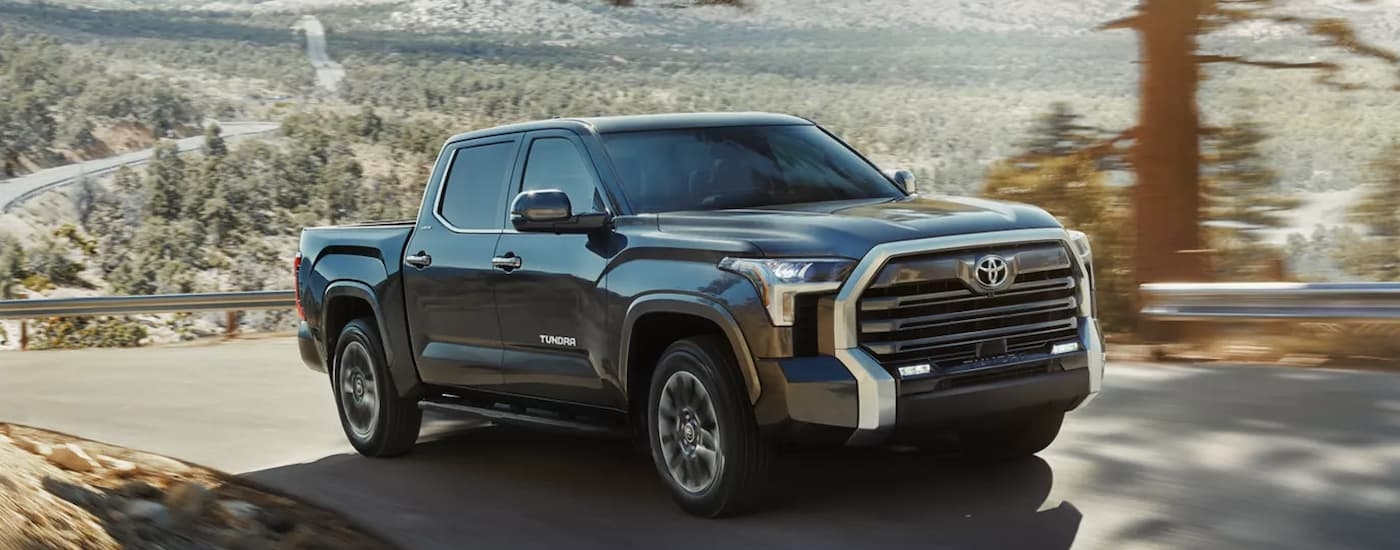Black 2026 Toyota Tundra for sale near Keene driving down a road.