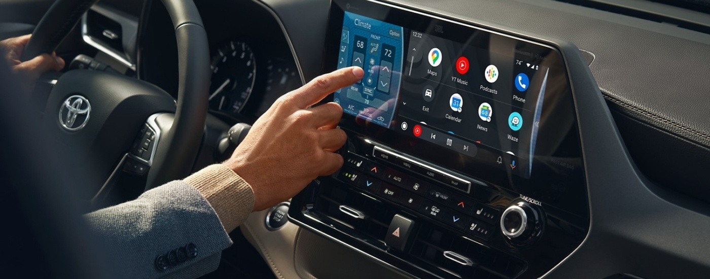 Person using the infotainment screen in a 2025 Toyota Highlander