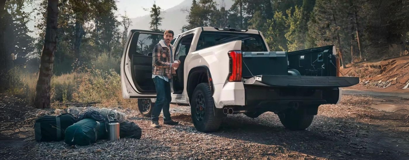 Person standing near the open door of a white 2025 Toyota Tundra TRD for sale in Westminster.