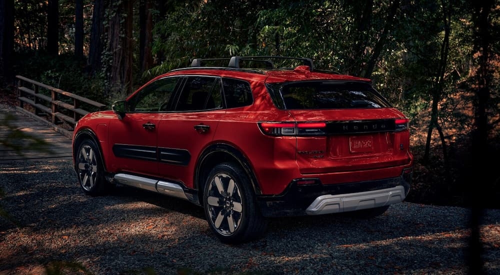 Rear of a red 2025 Honda Prologue parked in a forest.