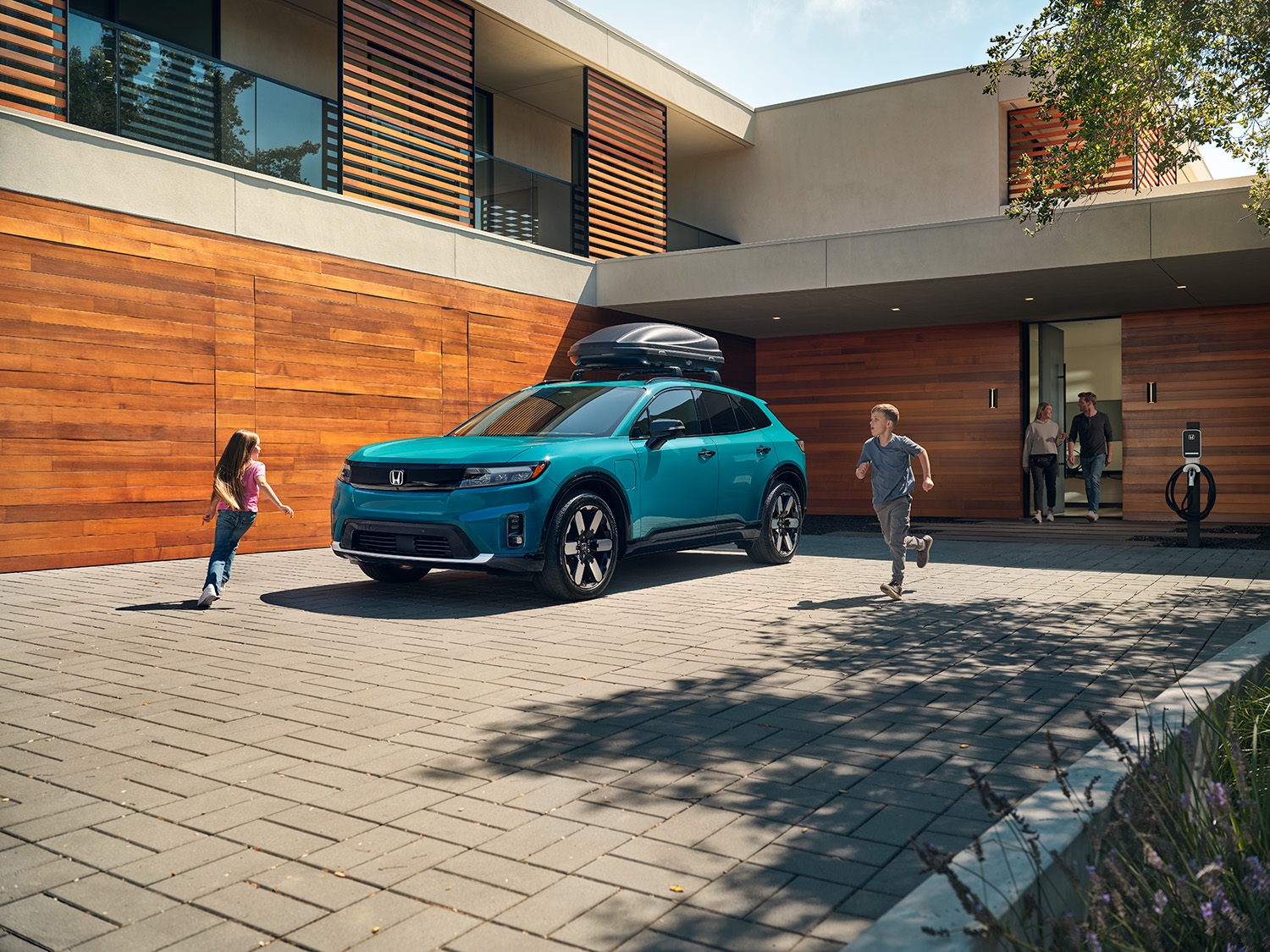 Family getting in teal Honda SUV