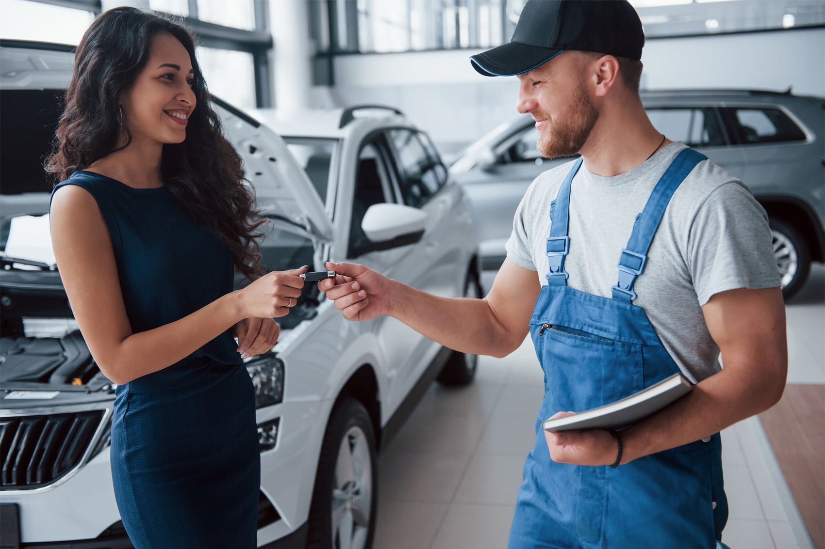 Service technician giving key to business woman